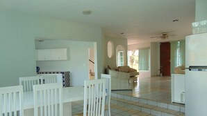 A spacious living area with a dining table and chairs, a sofa, and a refrigerator. - La Quinta de Alito (Xochitepec)