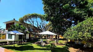 A well-maintained garden with a wooden deck, outdoor seating, and a fountain. - La Quinta de Alito (Xochitepec)