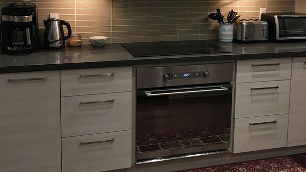 Una cocina moderna con electrodomésticos de acero inoxidable, microondas, cafetera y tostadora.