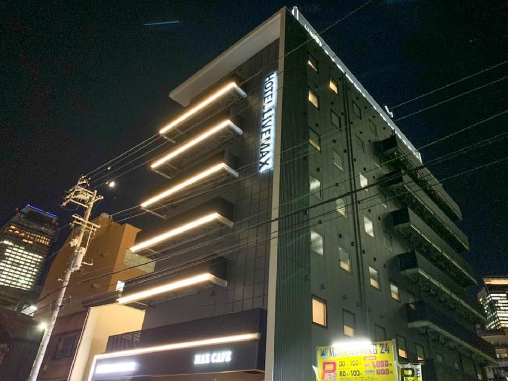 Un hotel con fachada moderna, entrada visible y un letrero que indica un estacionamiento.
