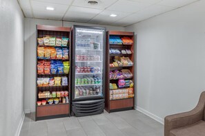 A snack and drink vending area with various brands of chips, sodas, and bottled water. - Suburban Studios at the University (Conway)