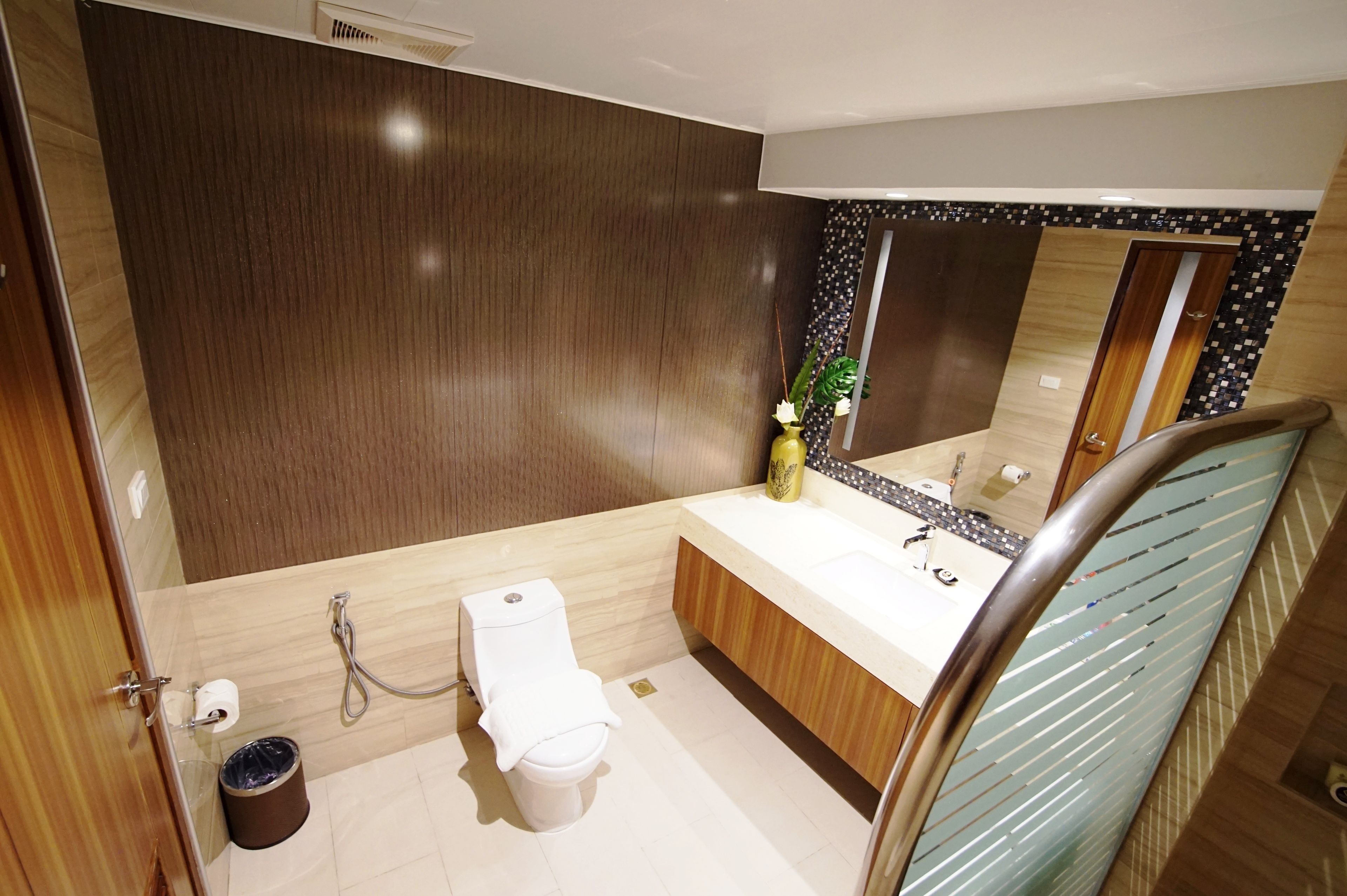 A modern bathroom with a toilet, sink, and mirror.