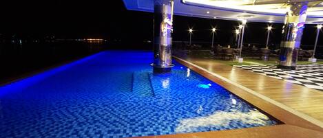 A pool area with a checkered floor and a blue-lit water feature.