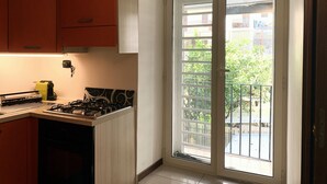 A kitchen with a gas stove, cabinets, and a window with a view of a balcony. - Azzurra Flat Bari Center (Bari)