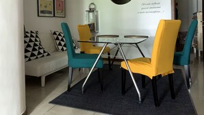 A dining area with a glass table, yellow chairs, and a black lantern on the wall. - Azzurra Flat Bari Center (Bari)