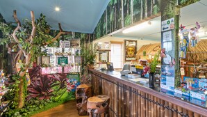 A reception area with a wooden counter, a computer, and various signs and posters. - Mandurah Caravan & Tourist Park (Furnissdale)
