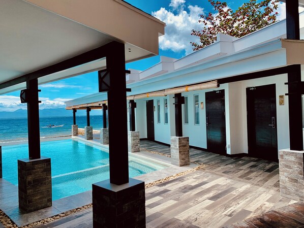 Ein modernes Hotel mit Pool, Holzboden und Meerblick.