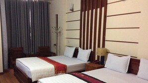 Une chambre d’hôtel avec deux lits, une tête de lit en bois, une table de chevet avec une lampe et une chaise.