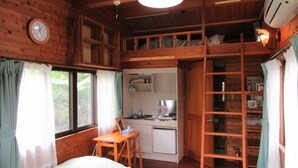 A wooden cabin with a bunk bed, a desk, a kitchenette, and a loft area. - Yambarunomori (Ogimi)