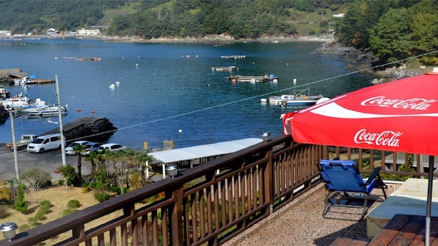 Marina com barcos, um guarda-sol com a marca Coca-Cola e uma cadeira em um deck.