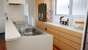 Una cocina moderna con un lavamanos empotrado, armarios de madera y una ventana con vidrio esmerilado.