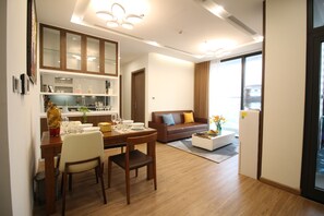 A modern living room with a dining area, a sofa, and a coffee table. - Jaan Apartment 29 Lieu Giai (Hanoi)