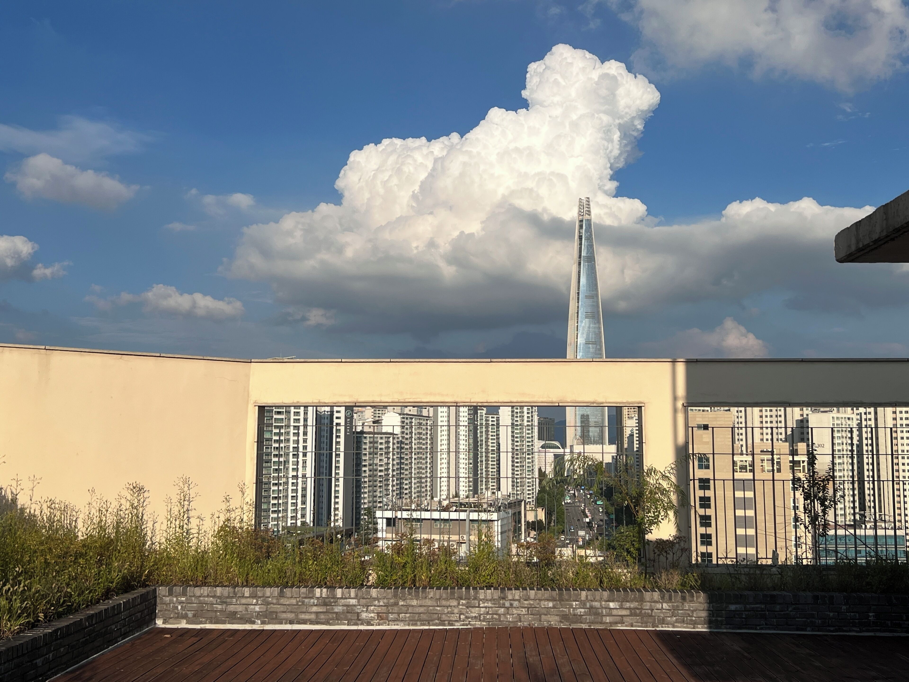 A high-rise building with a distinctive spire, surrounded by other residential buildings.