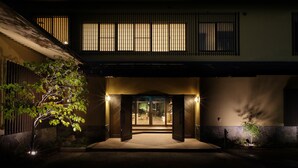 A traditional building with a wooden entrance, a stone wall, and a tree in the foreground. - Oyado Morinone - Adults Only (Kaminoyama)