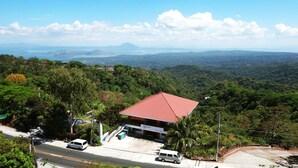 A building with a red roof, surrounded by lush greenery and a road with vehicles. - Stellar Potter's Ridge (Laurel)