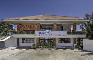 A two-story building with a tiled roof, a sign for "Stellar Pottery Bridge," and a sign for "Indomitable Dreams Kitchen."