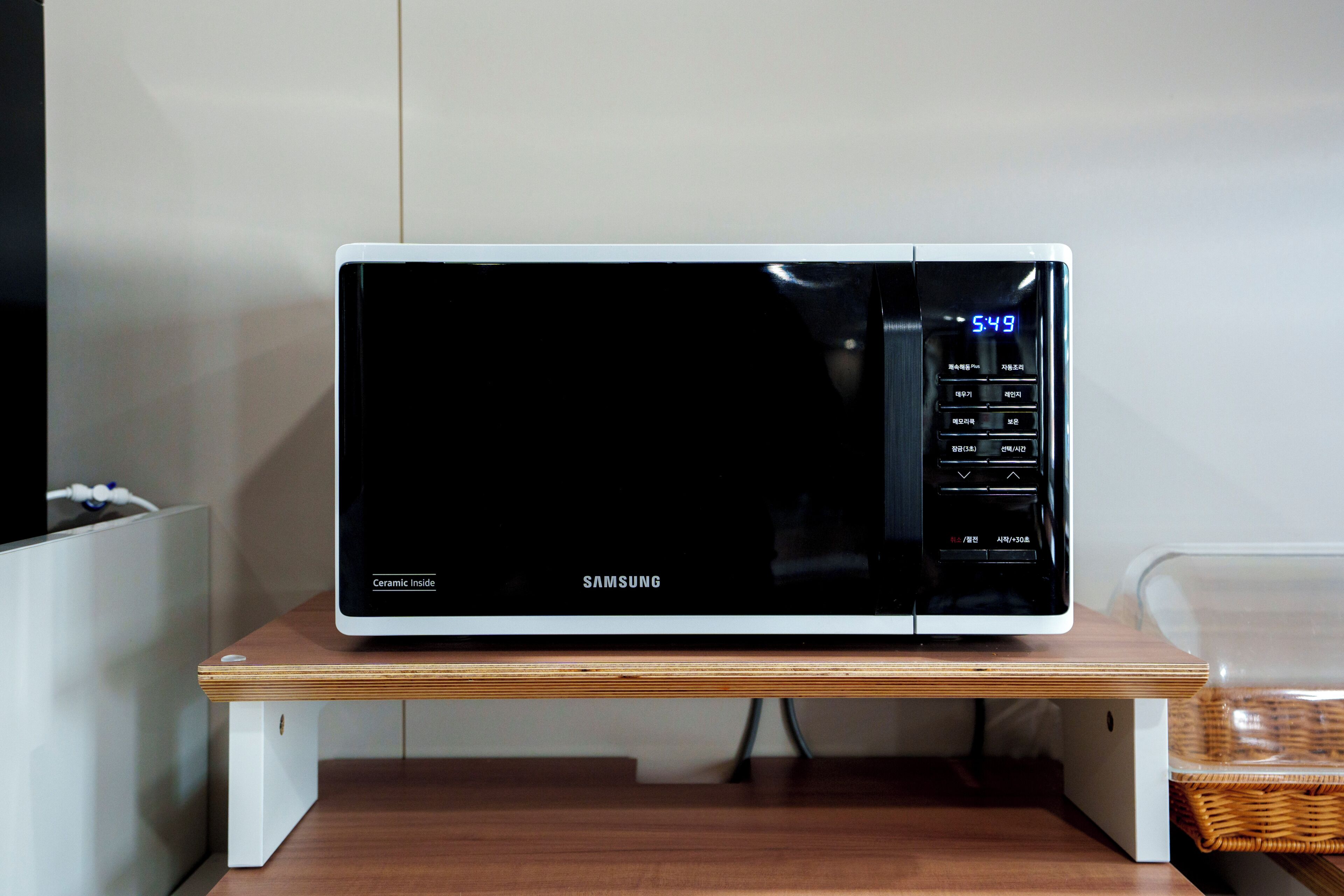 Un four à micro-ondes Samsung posé sur un support en bois.