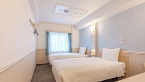 A hotel room with two beds, a window with curtains, a bedside table, a nightstand, and a wall-mounted light. - Toyoko Inn Ulsan Samsandong (Ulsan)