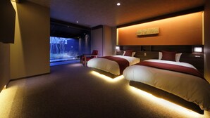 Une chambre d’hôtel moderne avec deux lits, un coin salon et une grande fenêtre.