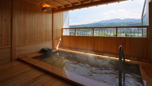Un sauna en bois offrant une vue sur les montagnes et le paysage urbain.