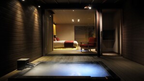 Une salle de spa moderne avec un jacuzzi, des murs en bois et un lit en arrière-plan.