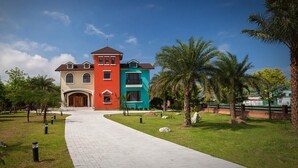 A large, multi-colored building with a central red section, flanked by blue and beige sections. - Forest B&B (Ji'an)