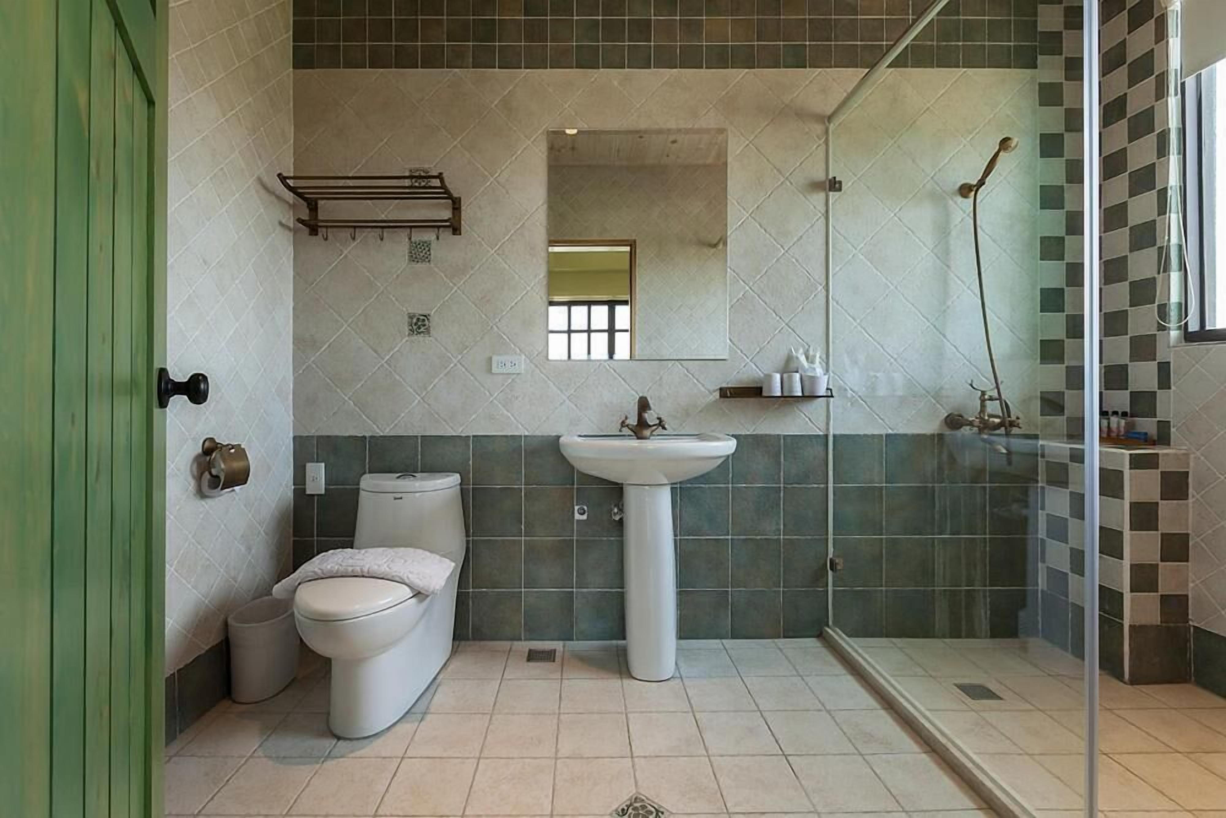 A bathroom with a toilet, sink, and shower.