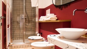 A modern bathroom with a glass-enclosed shower, a white sink with a large bowl, and a toilet. - Leucos B&B (Potenza)