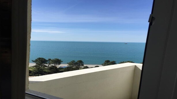 Blick auf das Meer vom Balkon bei blauem Himmel.