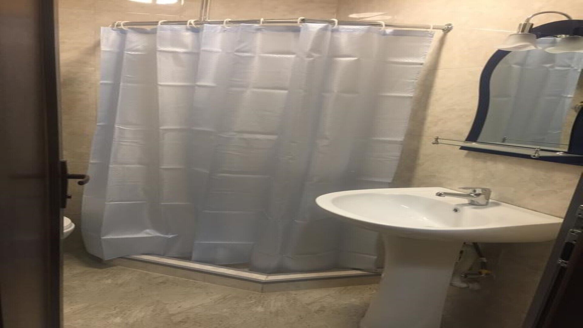 Un bagno con tenda doccia, lavandino e specchio.