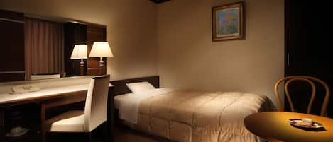 A hotel room with a bed, desk, chair, and a small table with a plate and a glass.