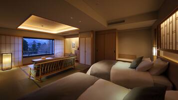A modern hotel room with a large window, a sofa, a bedside table, and a traditional Japanese sliding door.