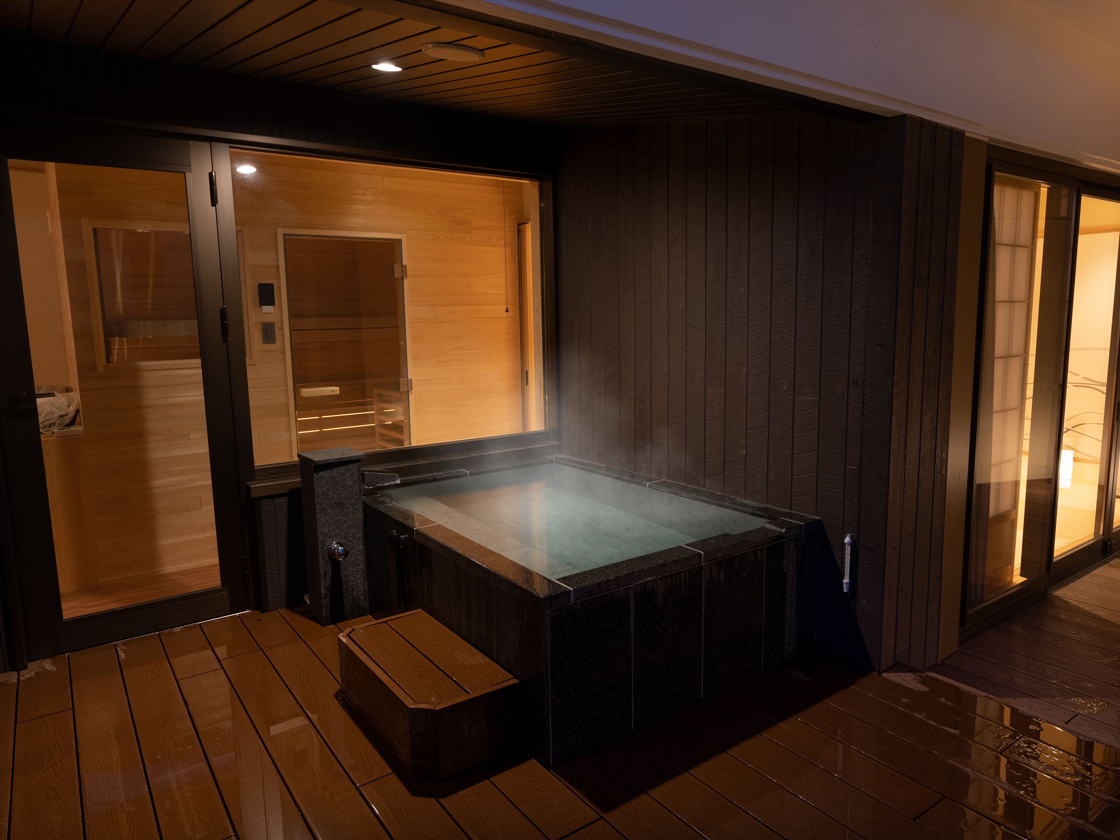 A hot spring bath area with wooden walls and a bench.