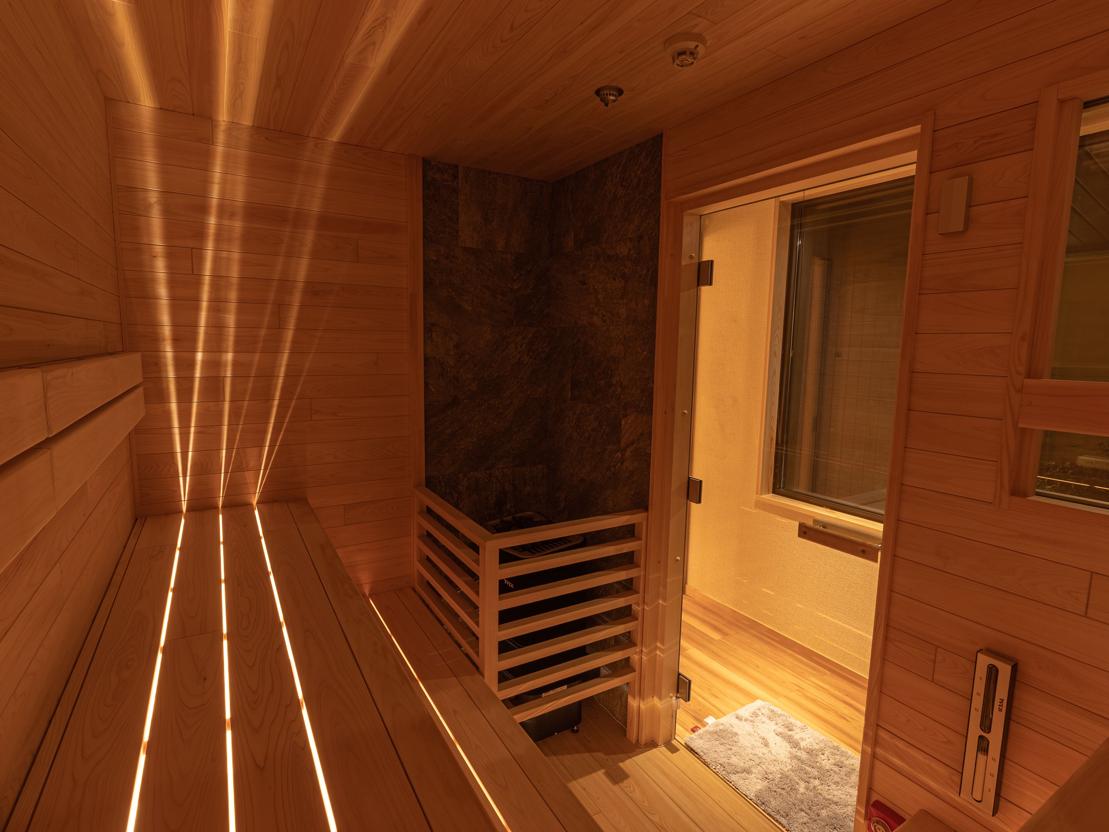 Un sauna avec des murs en bois et un banc.
