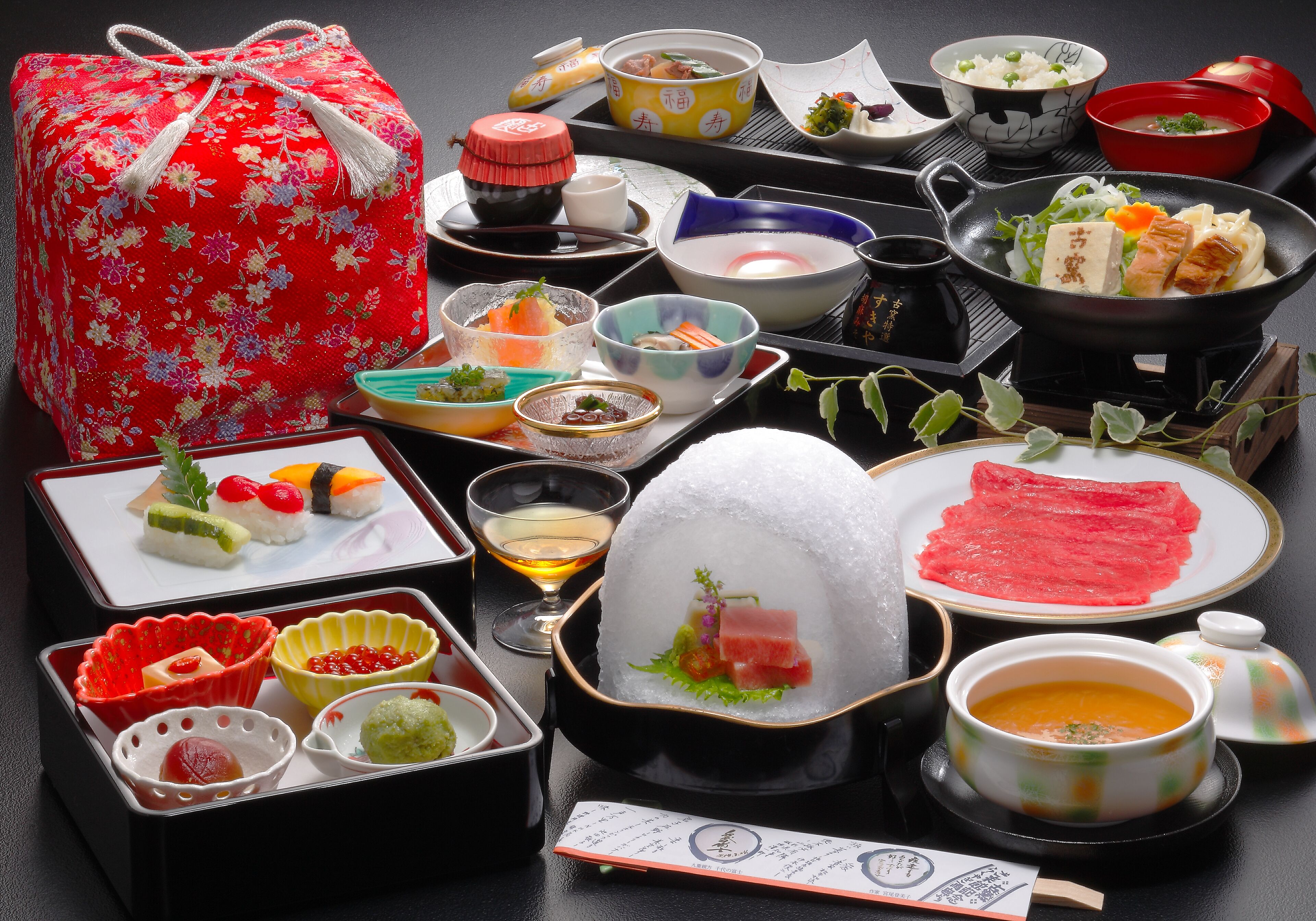 A variety of Japanese dishes and a traditional tea set on a table.