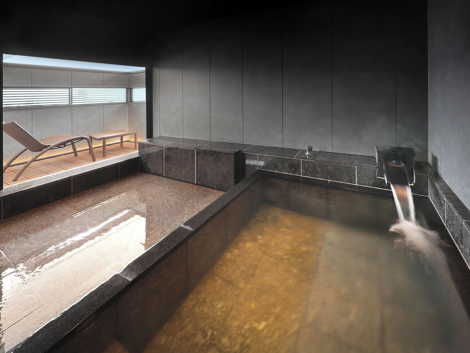 A spa area with a hot tub, seating, and a view of the outdoors.