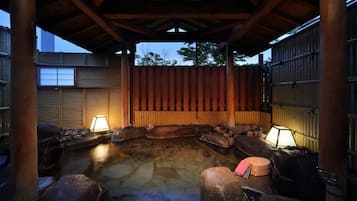 Un área de baños termales tradicionales con estructuras de madera y elementos de piedra.