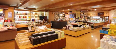 A well-lit store with wooden floors and shelves stocked with various products.