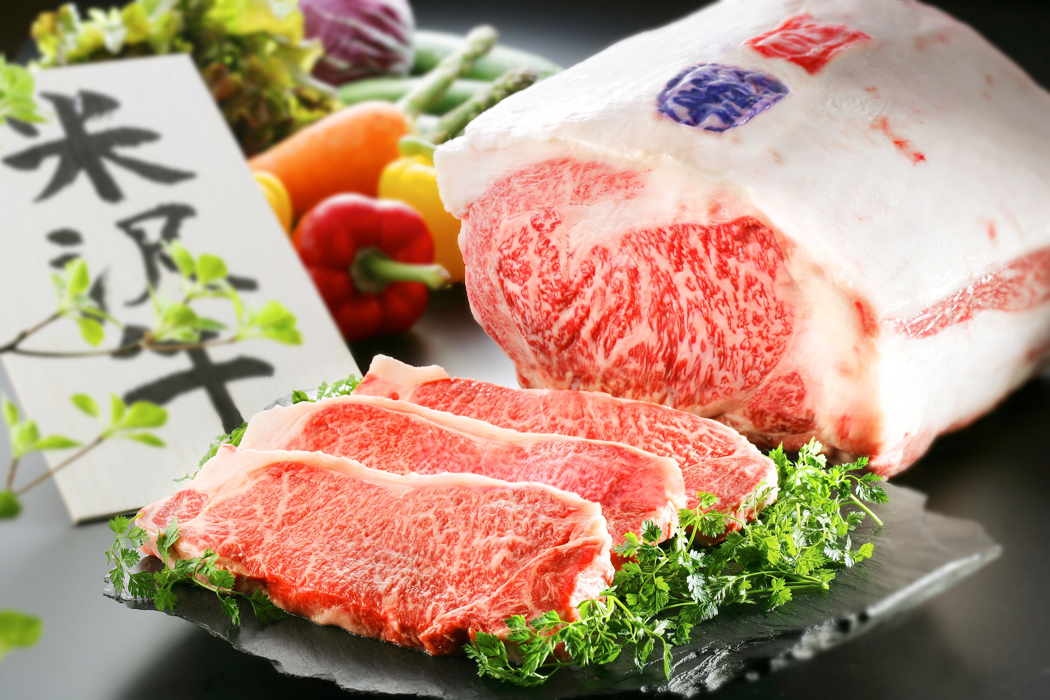 Presentación de carne de res cruda con un letrero y verduras.