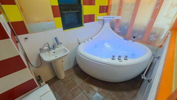 Un baño con una bañera grande, un lavamanos y un inodoro.