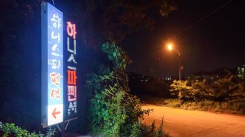 A nighttime street scene with a digital sign displaying information.