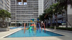 A swimming pool area with a water slide and play structures.