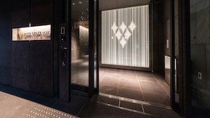 L’entrée de l’hôtel Vista Osaka présente un design moderne, avec une porte en verre, une enseigne et un mur décoratif à motifs.