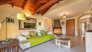 A cozy living room with a sofa, a coffee table, and a fireplace. - Villa Camelia panoramic villa facing the sea (Torre Delle Stelle (Maracalagonis))