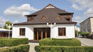 Un hôtel appelé « Hôtel Medelean », doté d’une façade symétrique, de grandes fenêtres et d’un jardin bien entretenu.