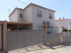 A two-story house with a tiled roof, a gated entrance, and a small garden area with flowers. - Villa private pool sea view 5 min walk, air conditioning, handicapped access 1 to 7P+2optional  (San Juan de los Terreros)