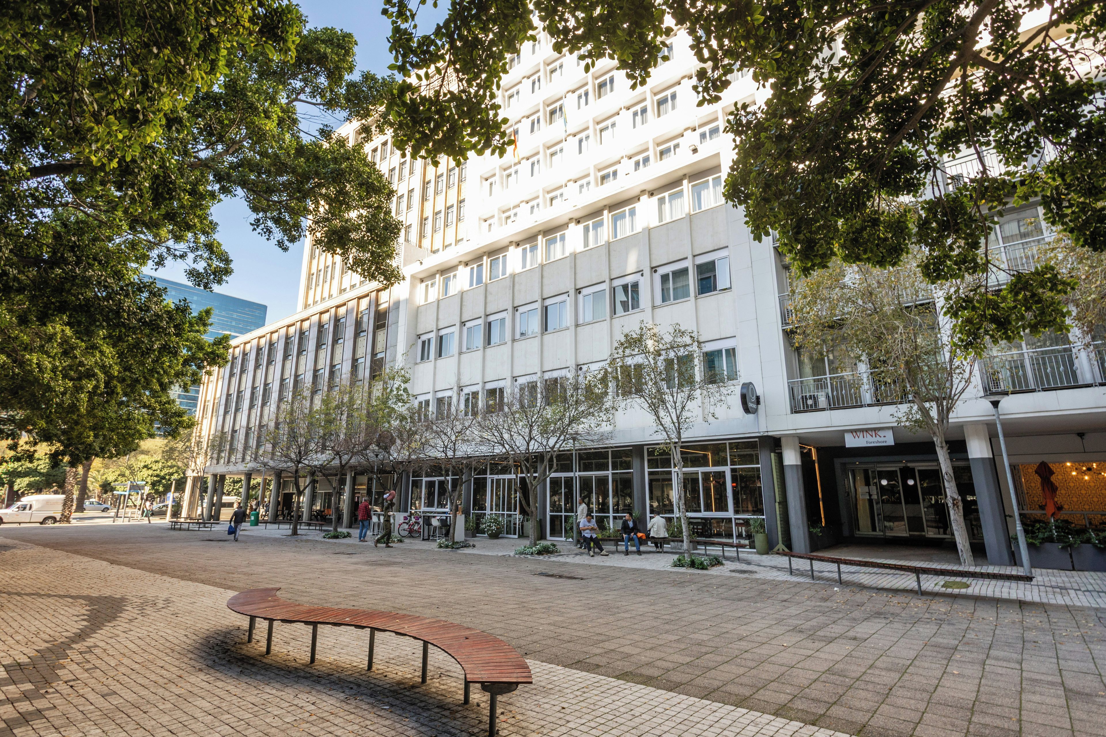 A modern building with multiple floors, large windows, and a ground-level commercial space.