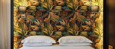 A room with a bed, two wall-mounted lamps, and a patterned wall.