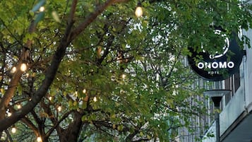 Un árbol con luces colgantes y el letrero de un hotel.