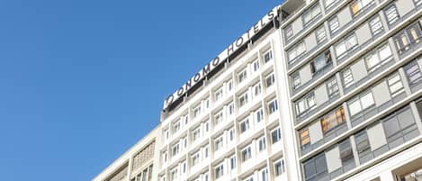 Um edifício de hotel com vários andares e uma placa chamativa com a palavra 'HOTEL'.